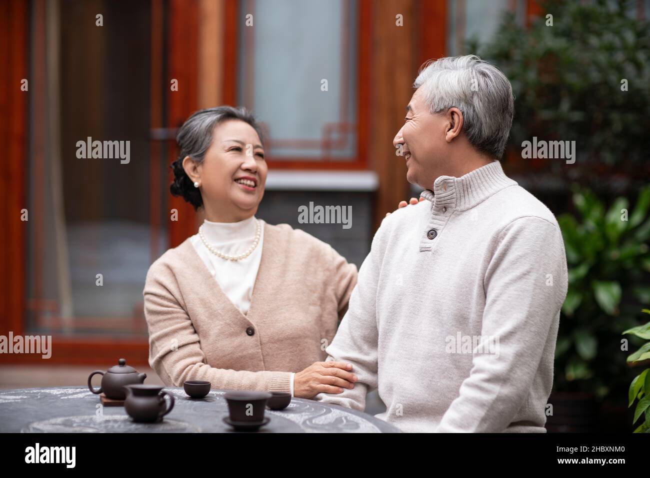 Old couple drinking tea and chatting in the courtyard Stock Photo