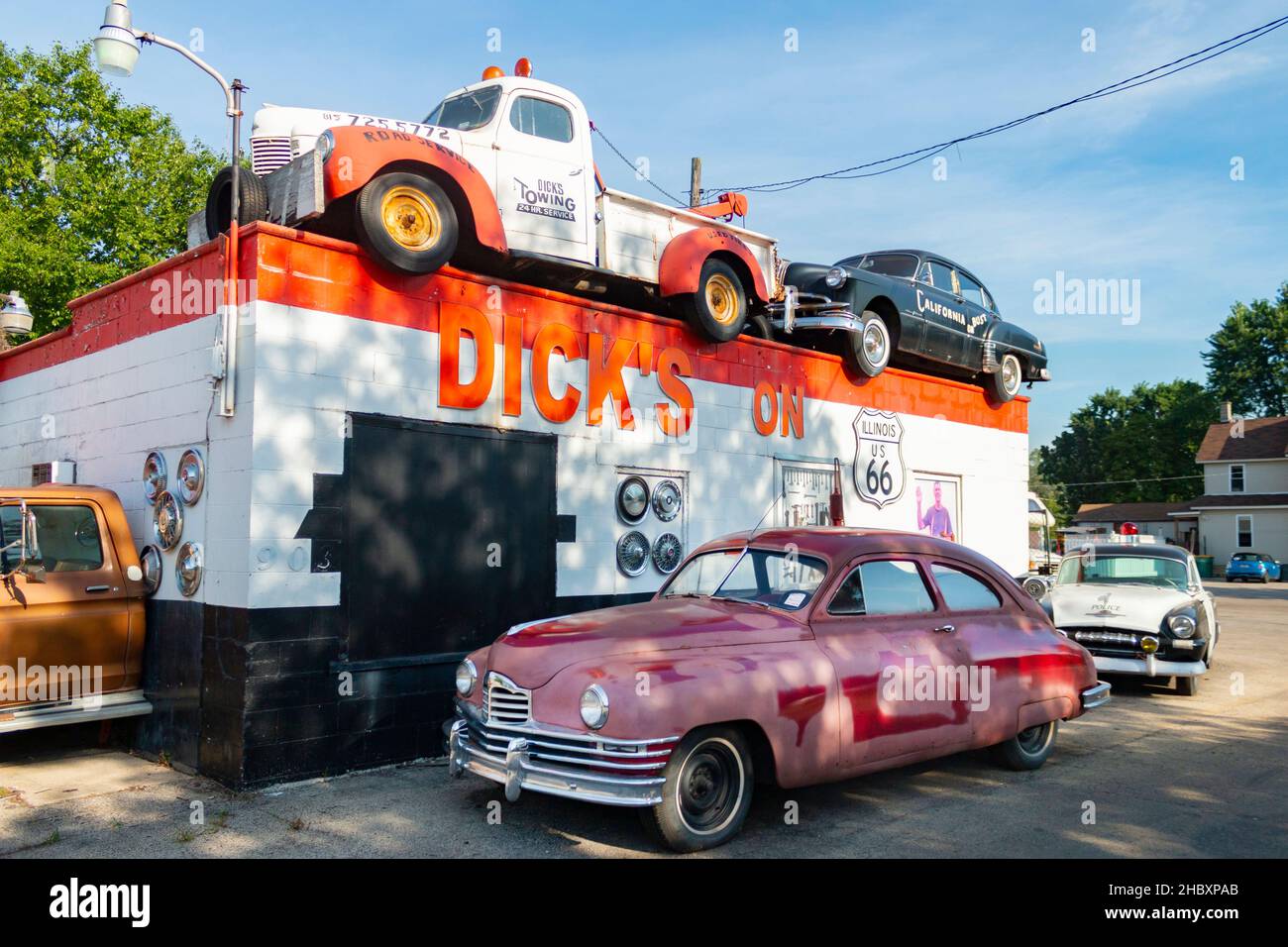 vintage tow truck 1948 Packard sedan Plymouth police car parked outside