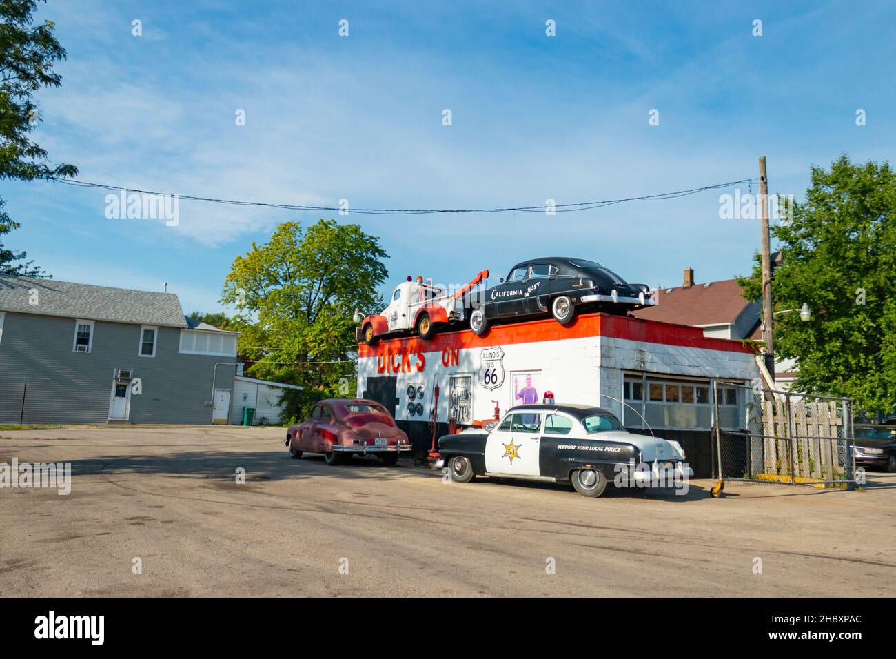 vintage tow truck 1948 Packard sedan Plymouth police car parked outside