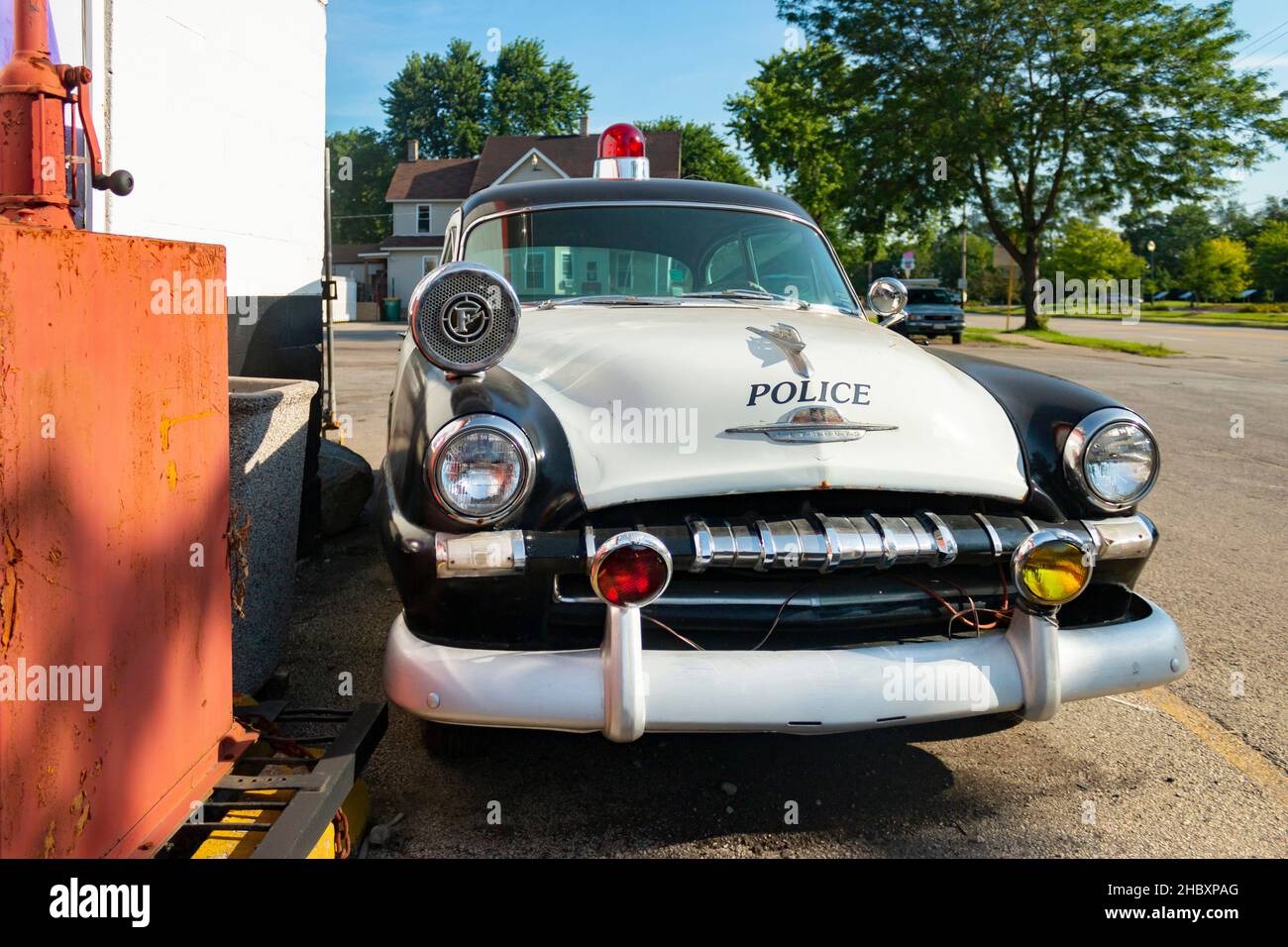 vintage Plymouth police car parked outside the repair shop Dick's On 66