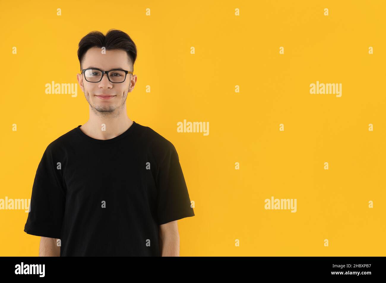 Young man in glasses on yellow background Stock Photo