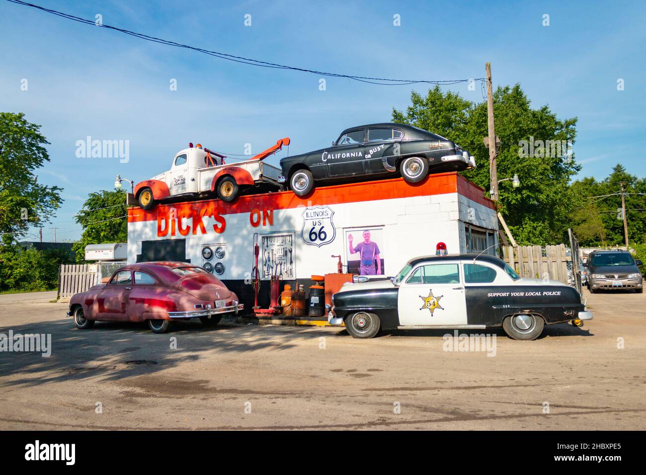 vintage tow truck 1948 Packard sedan Plymouth police car parked outside