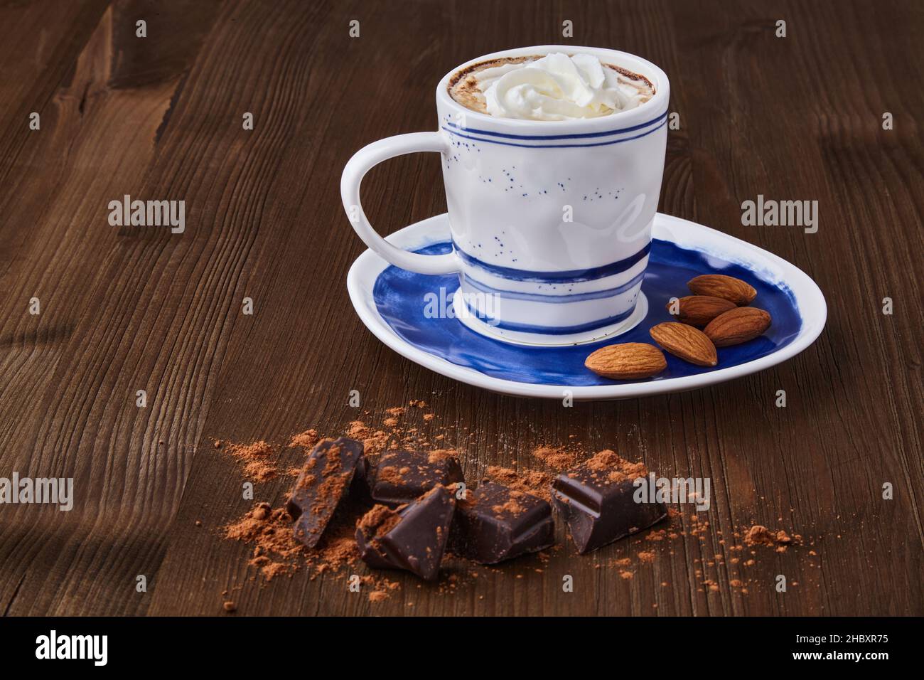 Cup of coffee with whipped cream and almonds, chopped chocolate Stock Photo