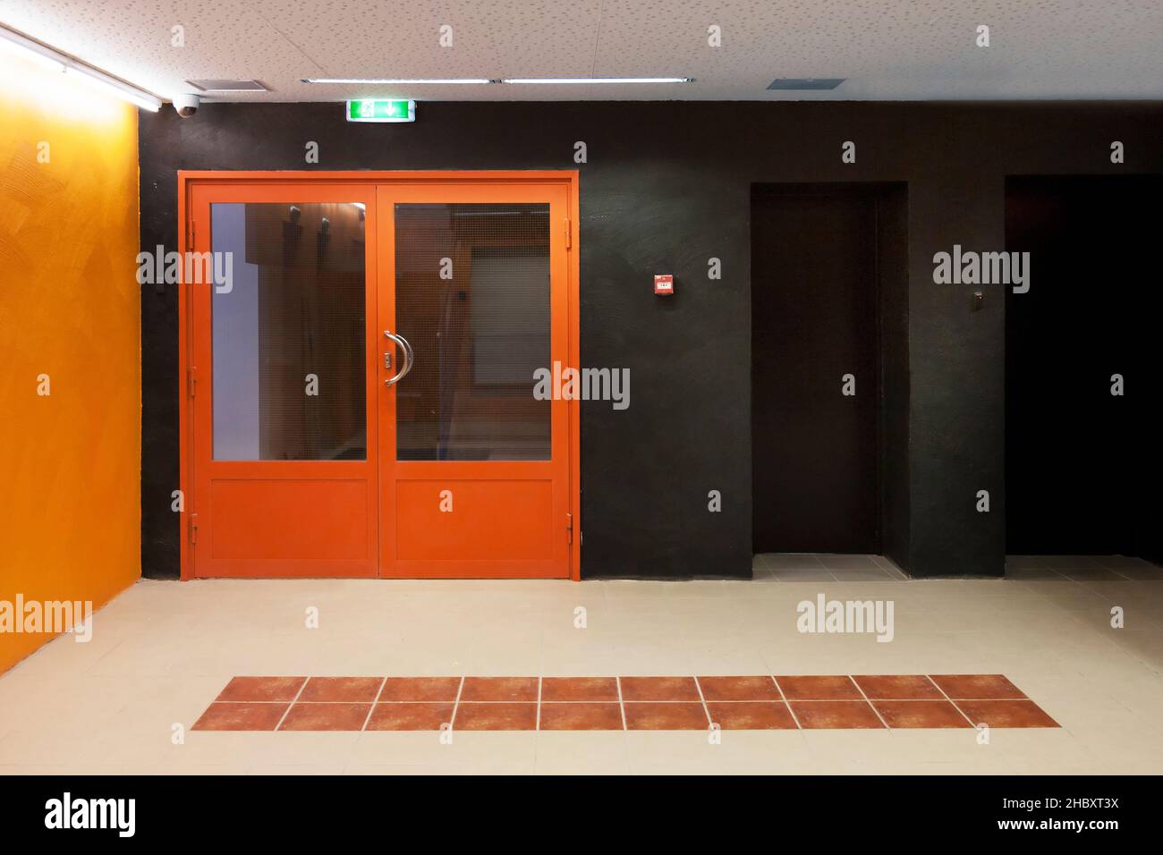 Corridor with orange entrance doors, orange and black colour scheme ...