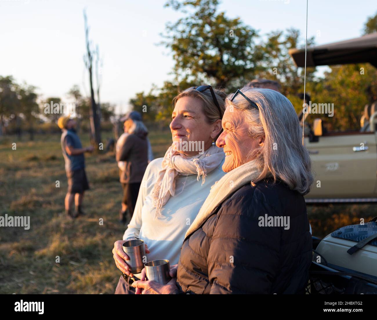 Two people, a mature woman and her mother, standing side by side at sunset Stock Photo