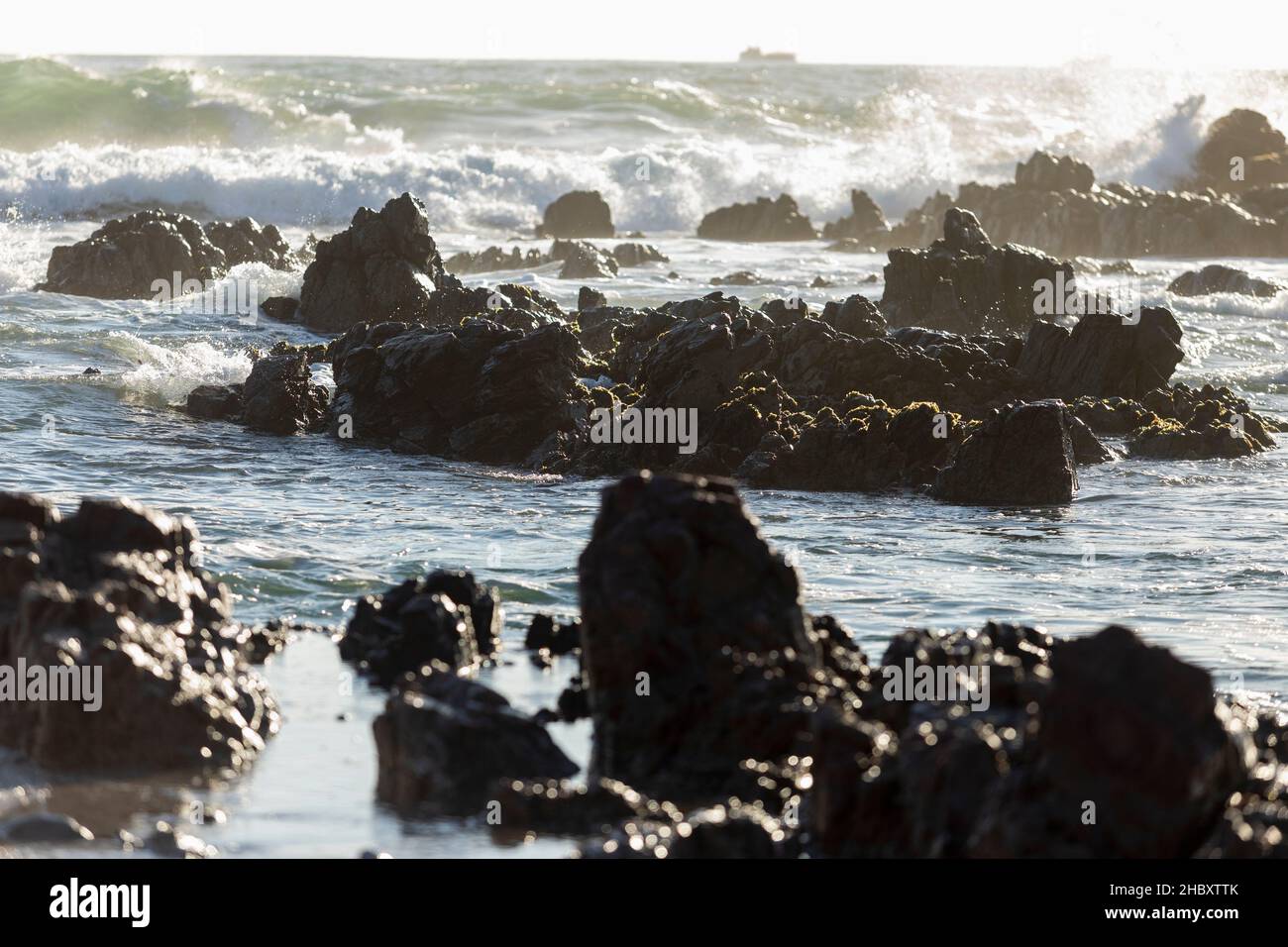 Jagged rocks and waves breaking on shore on the Atlantic coastline. Stock Photo