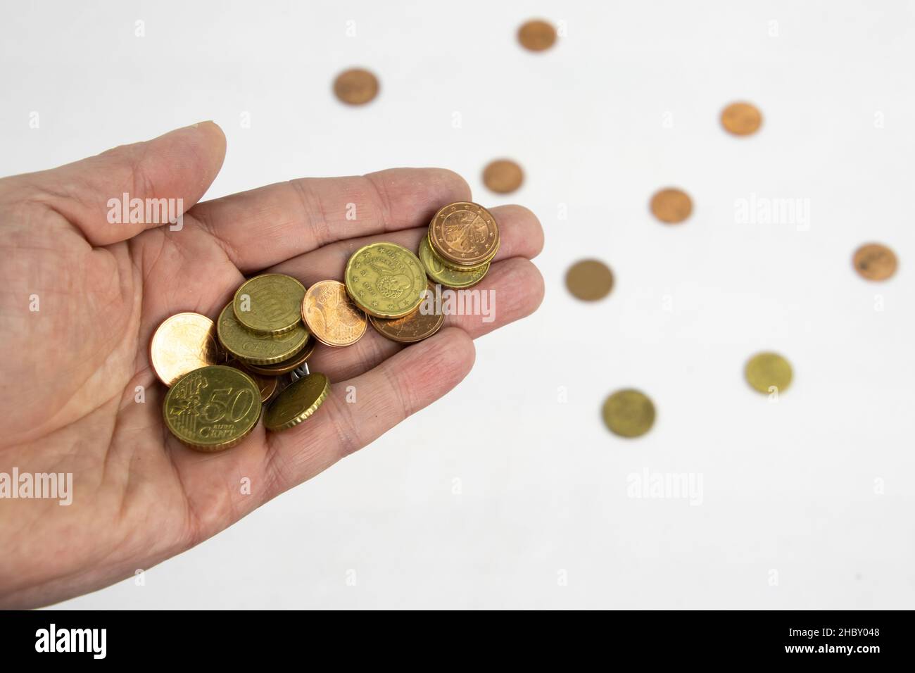 Hand holding euro coins isolated on white background, concept of poverty Stock Photo