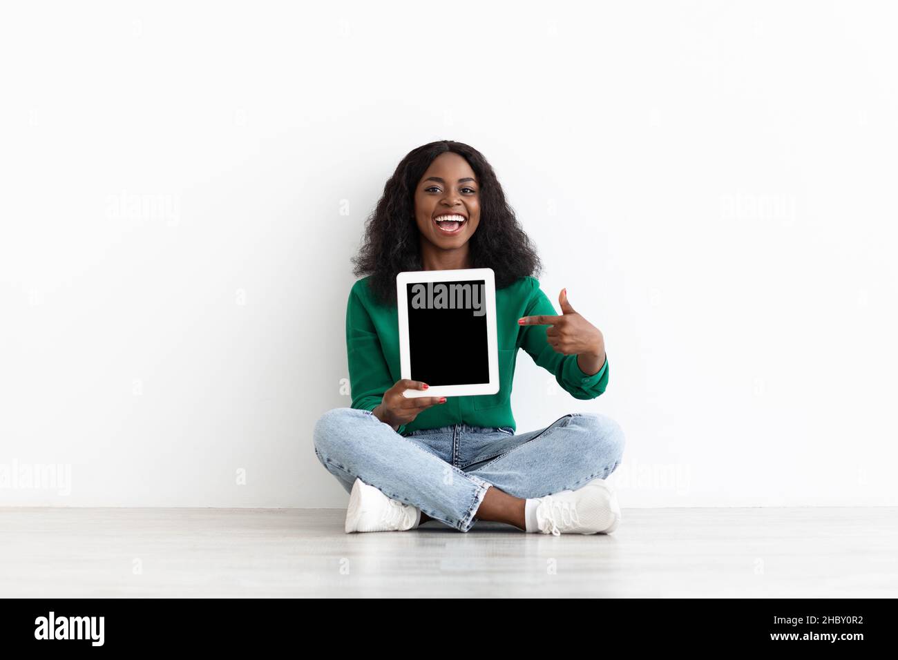 Attractive black woman showing modern digital tablet with empty screen ...