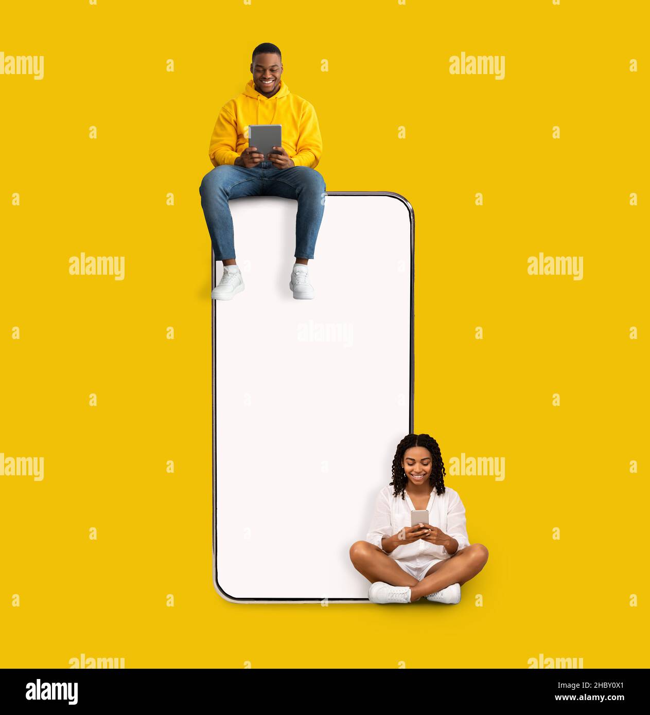 Couple sitting on white empty smartphone screen and using phones Stock Photo