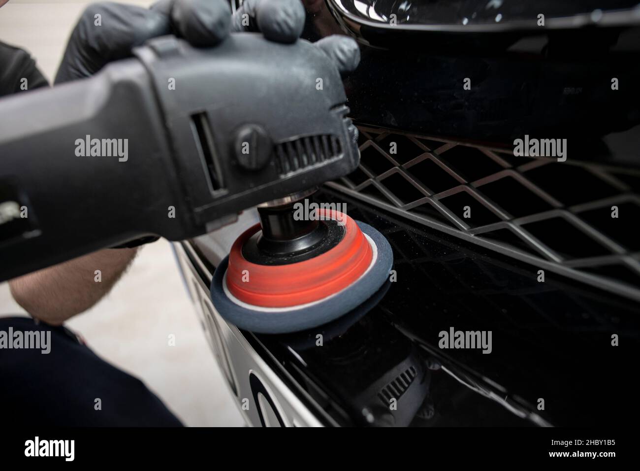 hand with a polishing tool cleaning a bumper on a black car, close up, detail Stock Photo Alamy