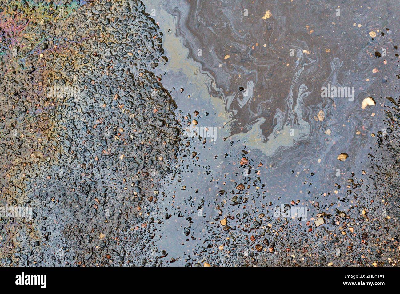 Gas stain on wet asphalt caused by a leak under a car or truck Stock Photo Alamy