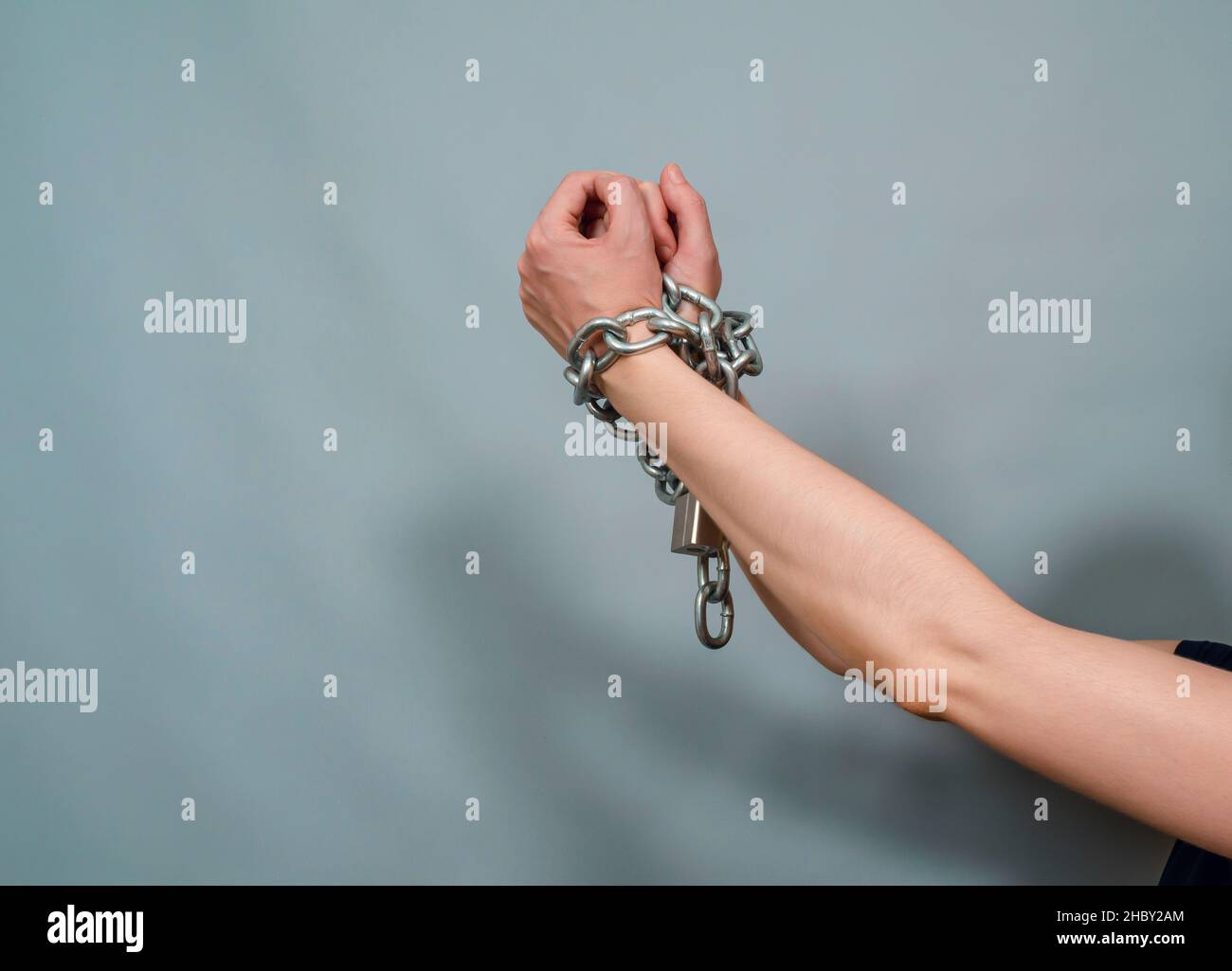 Hands chained together. Concept of violence. Chain with lock Stock