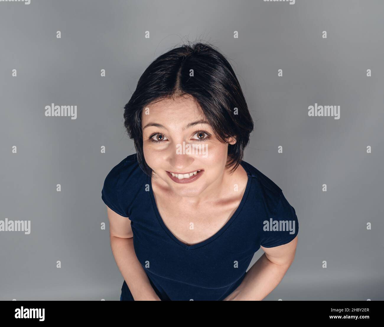 Portrait of cheerful dark-haired woman. Top view. Emotions of joy and happiness. Snow-white smile. Stock Photo