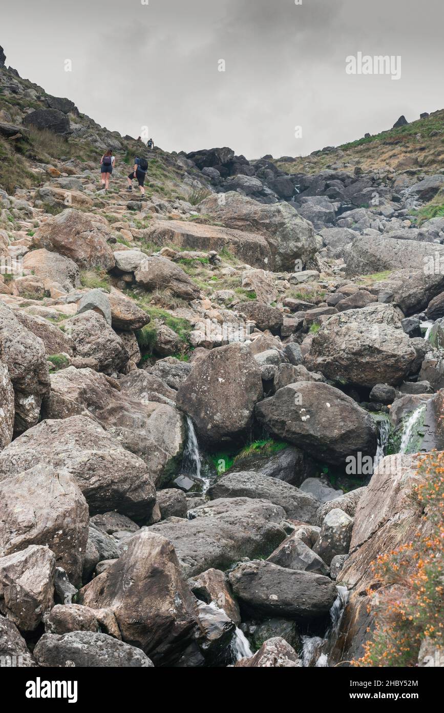 Stickle Ghyll, view of a young couple ascending Stickle Ghyll, a challenging trail leading up to the Langdale Pikes, Lake District, Cumbria, UK Stock Photo