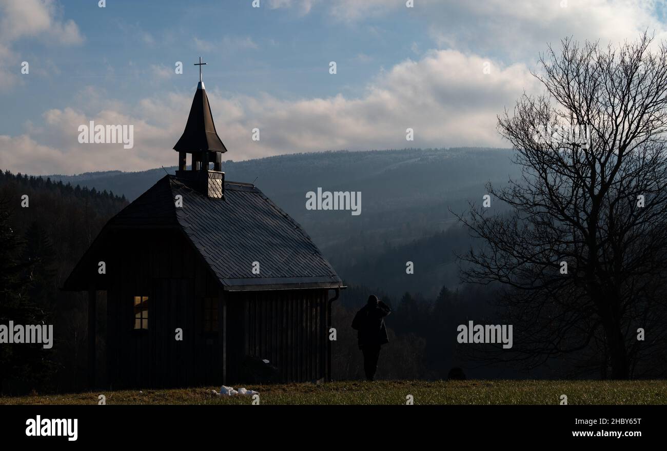 22 December 2021, Saxony, Oberlochmühle: The sun shines on the chapel at the bell hiking trail in Oberlochmühle near Seiffen. After a frosty midweek, temperatures climb into the plus range over the Weichnacht days. Photo: Hendrik Schmidt/dpa-Zentralbild/dpa Stock Photo