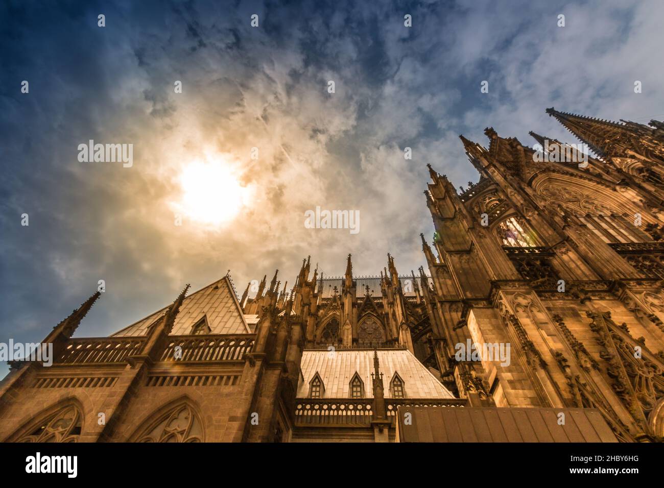 A low angle shot of the cathedral and the sun through clouds in Cologne ...