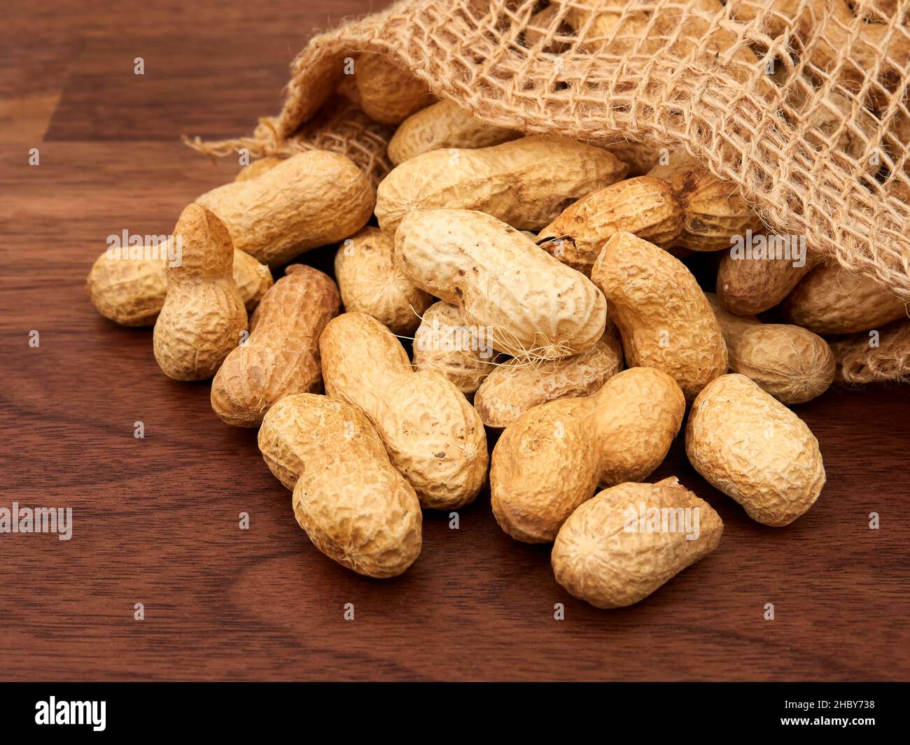 Raw peanuts in a bag, uncooked, not salted. on a walnut table Stock Photo