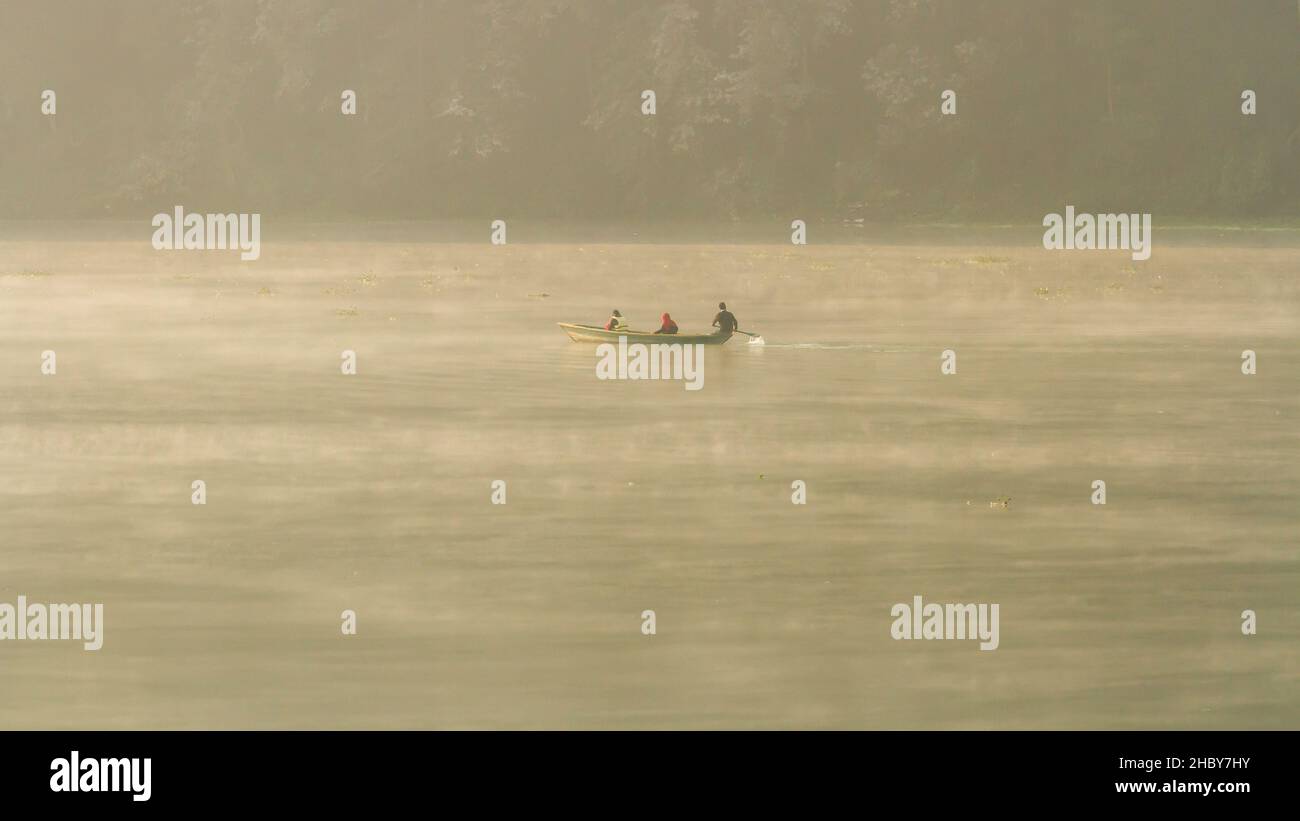 Pokhara, Nepal - November 21, 2015: Tourists row on a boat across Phewa lake. Stock Photo