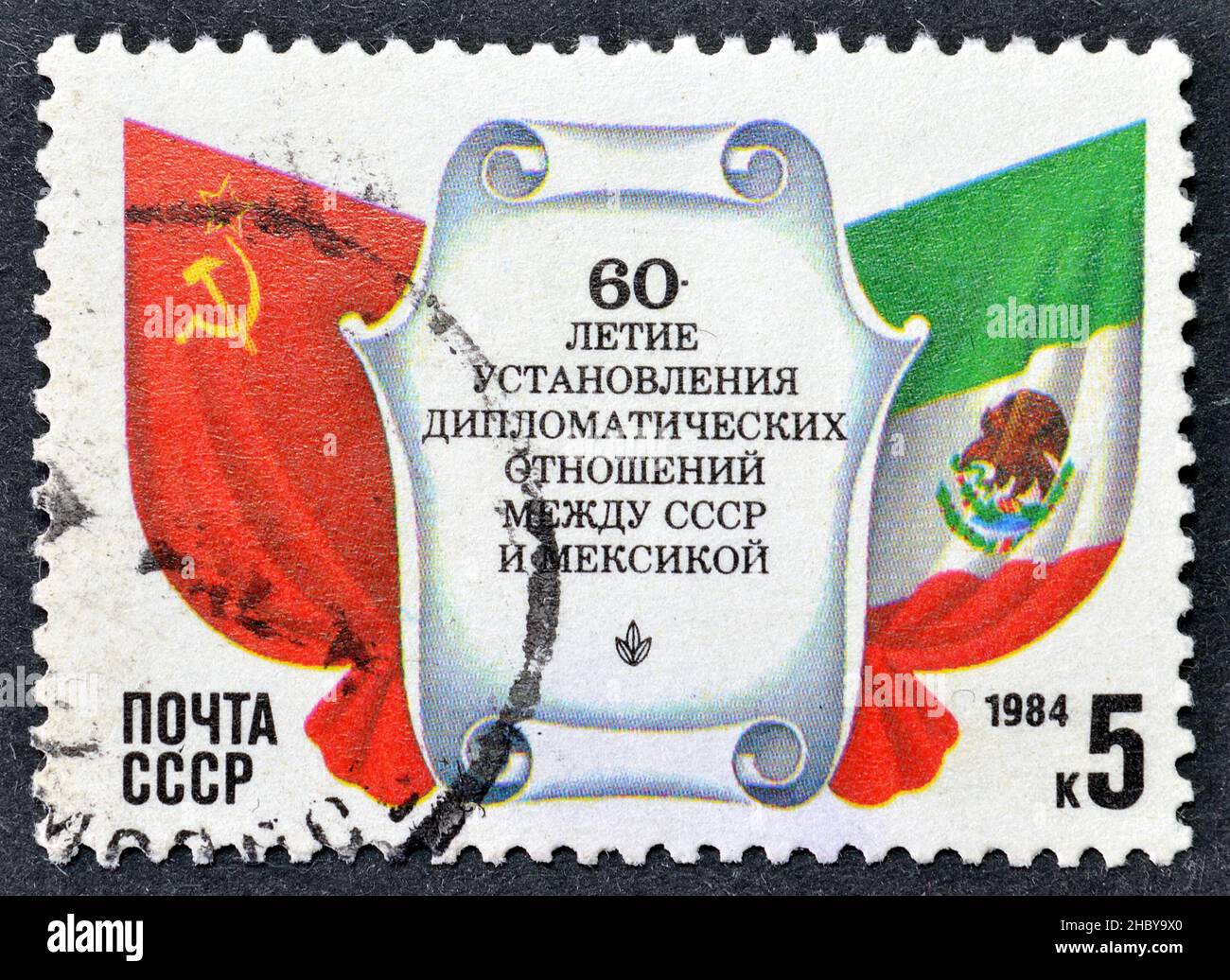 Cancelled postage stamp by USSR, that shows Flags, 60th Anniversary of USSR-Mexico Diplomatic Relations, circa 1984. Stock Photo