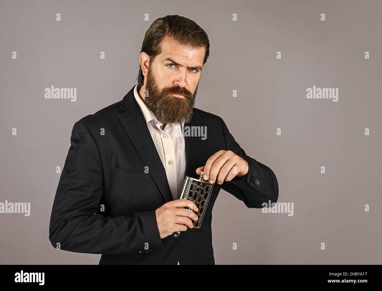Have alcohol drink with you. Always with me. Flat metal bottle for alcohol. man with elegant look. hipster in suit hold metal flask for alcohol Stock Photo