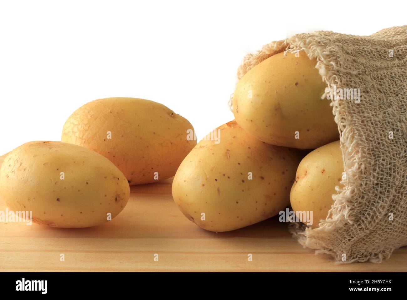https://c8.alamy.com/comp/2HBYCHK/potato-sticking-out-of-sack-on-wooden-table-white-background-2HBYCHK.jpg