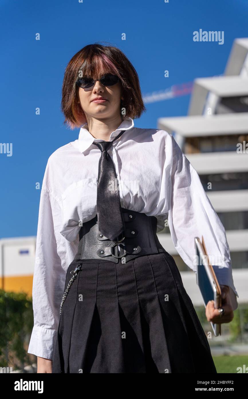portrait of a girl in work clothes with a leather corset around her waist, view from below, vertical photo Stock Photo
