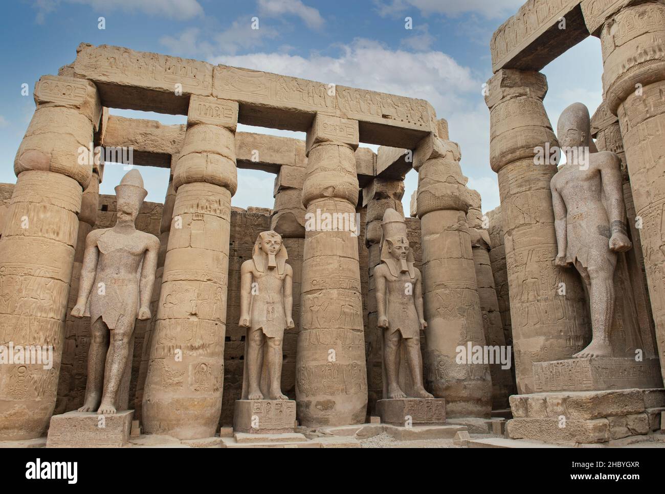 Large statue of Ramses II in ancient egyptian Luxor Temple with columns ...