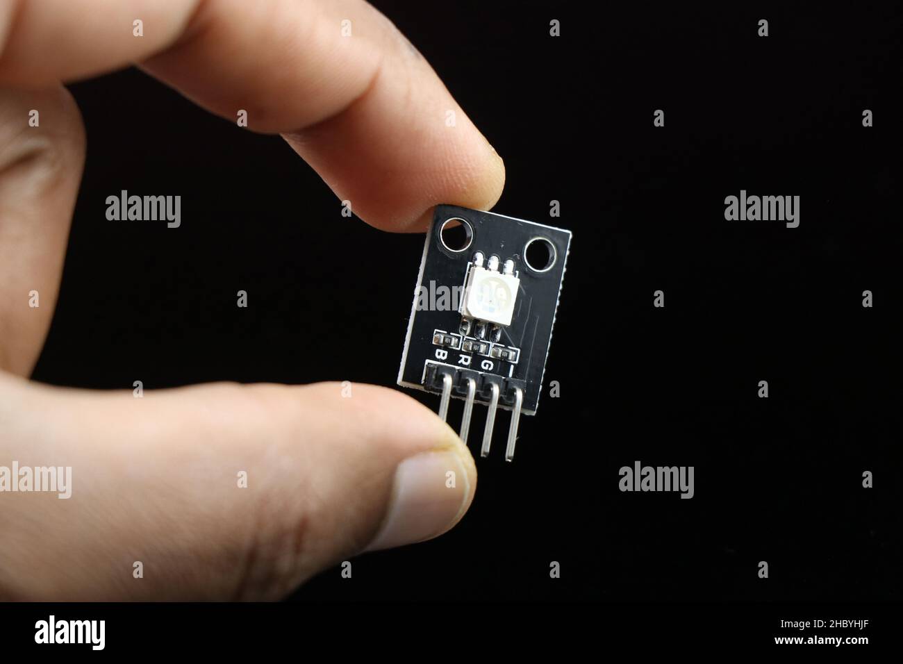 SMD RGB LED module for programmable microcontroller boards held in hand isolated on black Stock Photo
