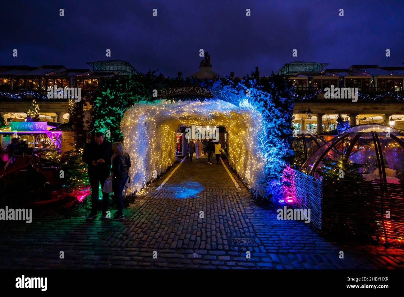 The colourful illuminated entrance to Covent Garden Christmas Village in Covent Garden, London