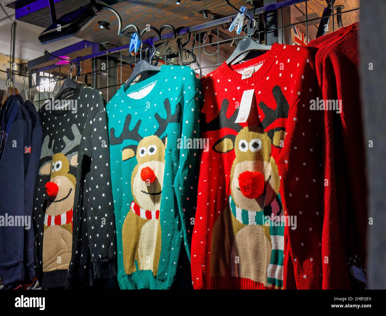 Typical colourful seasonal Rudolph the reindeer sweaters on display for sale in a stall in Covent Garden, London WC2 Stock Photo