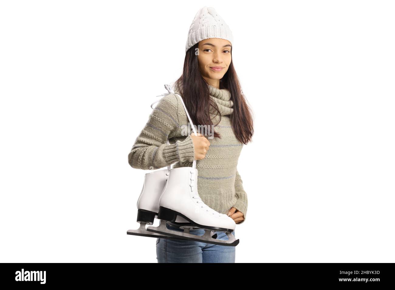Young casual woman carrying ice skates on her shoulder isolated on