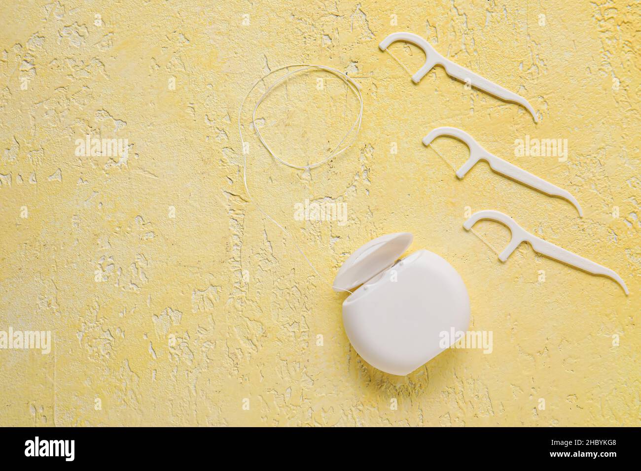 Dental floss with toothpicks on yellow background Stock Photo - Alamy
