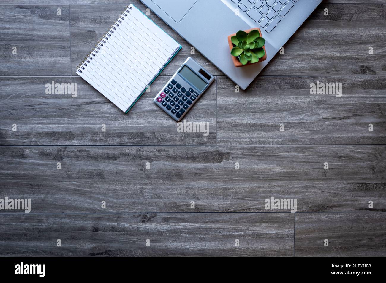Gray wooden desk table workspace with laptop computer and supplies for business and remote work from home.  Top view with copy space flat lay. Stock Photo