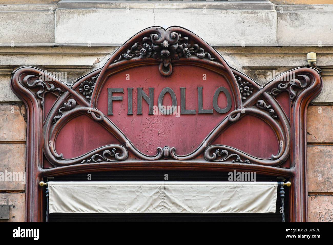 Close-up of the wooden sign in Art Nouveau style of the Finollo tailored shirts and silk ties historical shop in the centre of Genoa, Liguria, Italy Stock Photo