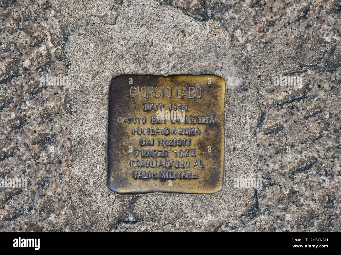 The 'stumbling block' by Gunter Deming dedicated to the memory of Giorgio Labò, partisan shot by the Nazis, placed on a sidewalk in Via Roma, Genoa Stock Photo