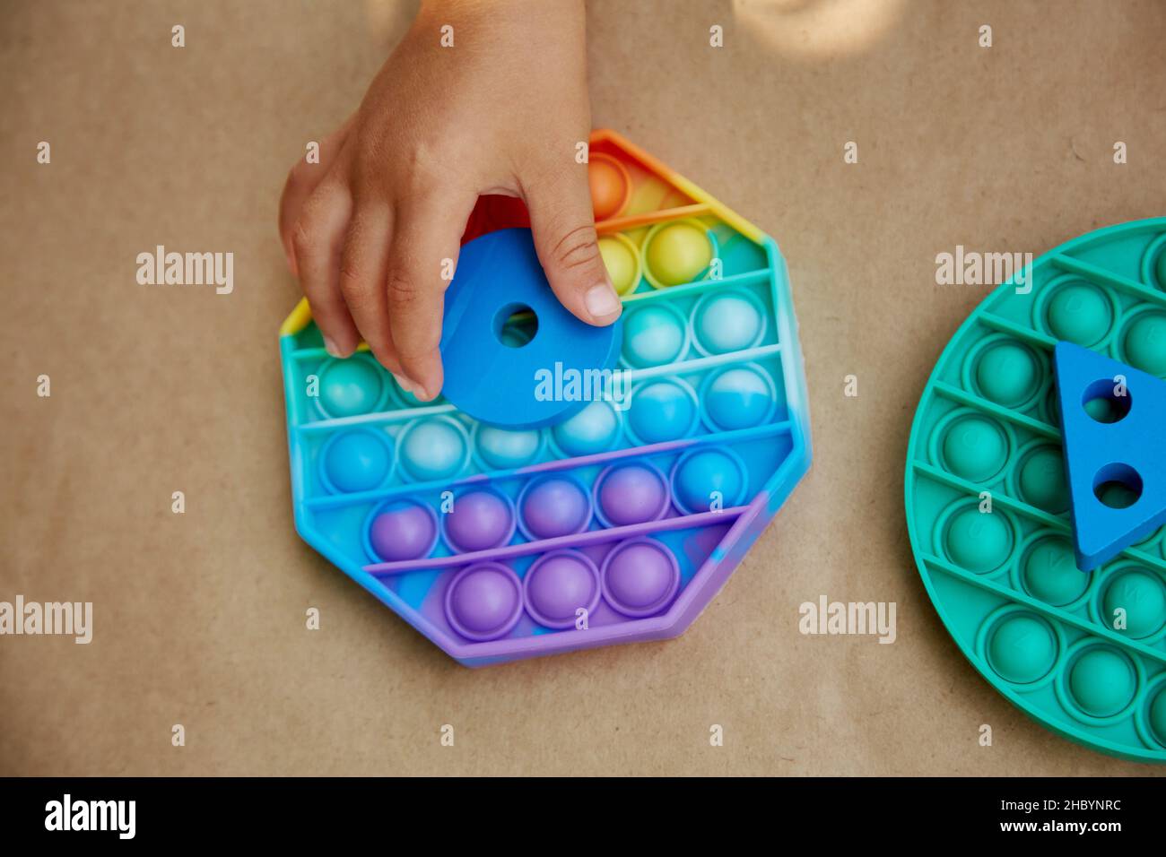 Baby hands plays with colorful antistress sensory toy fidget push pop ...