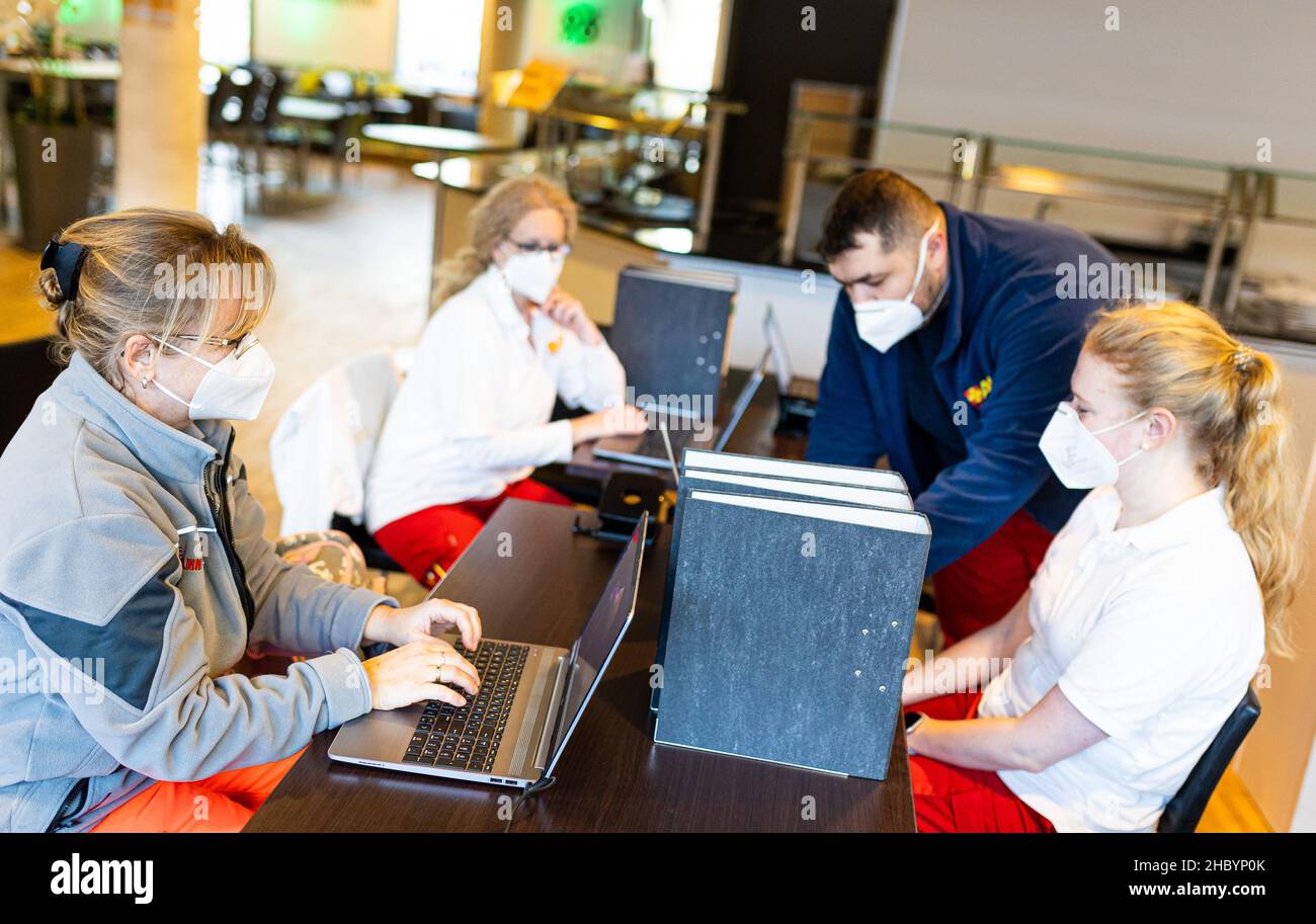 Hanover, Germany. 22nd Dec, 2021. Helpers work on laptops during a vaccination campaign at the HDI Arena, Hannover 96's stadium. Credit: Moritz Frankenberg/dpa/Alamy Live News Stock Photo