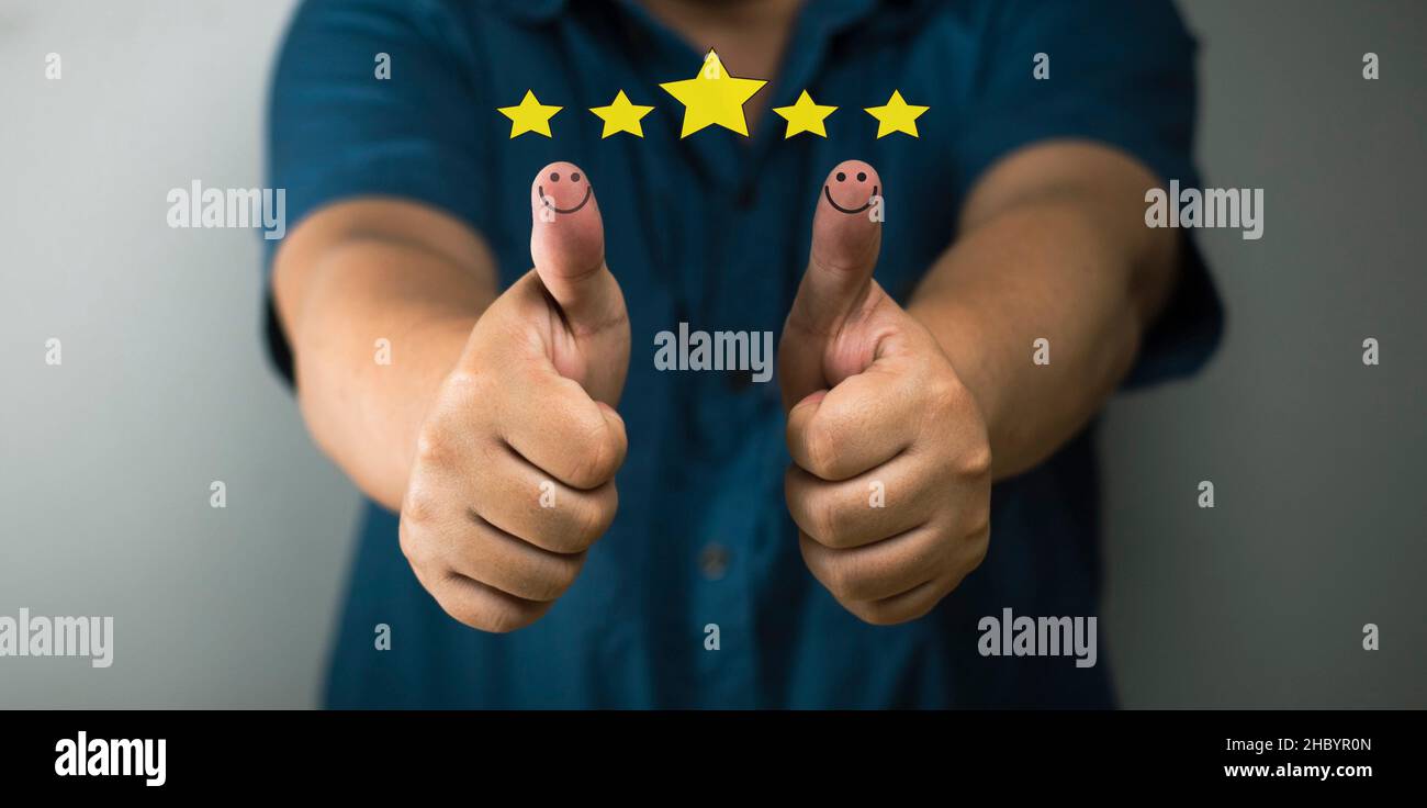 customer satisfaction concept thumbs up smiley face icon rating 5 stars positive concept positive satisfaction about products, services. Stock Photo