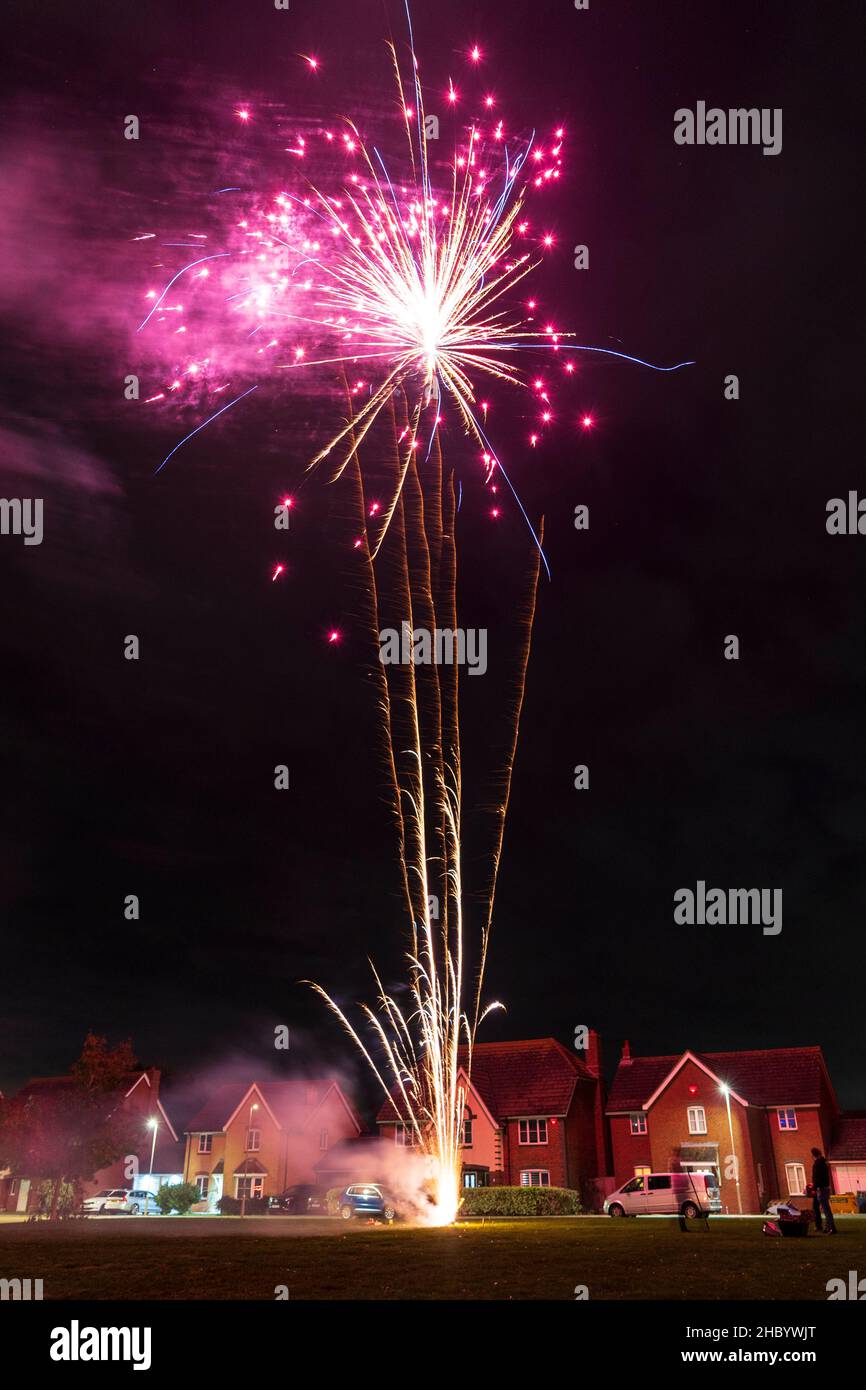 Firework display on village green with fireworks exploding on top of a