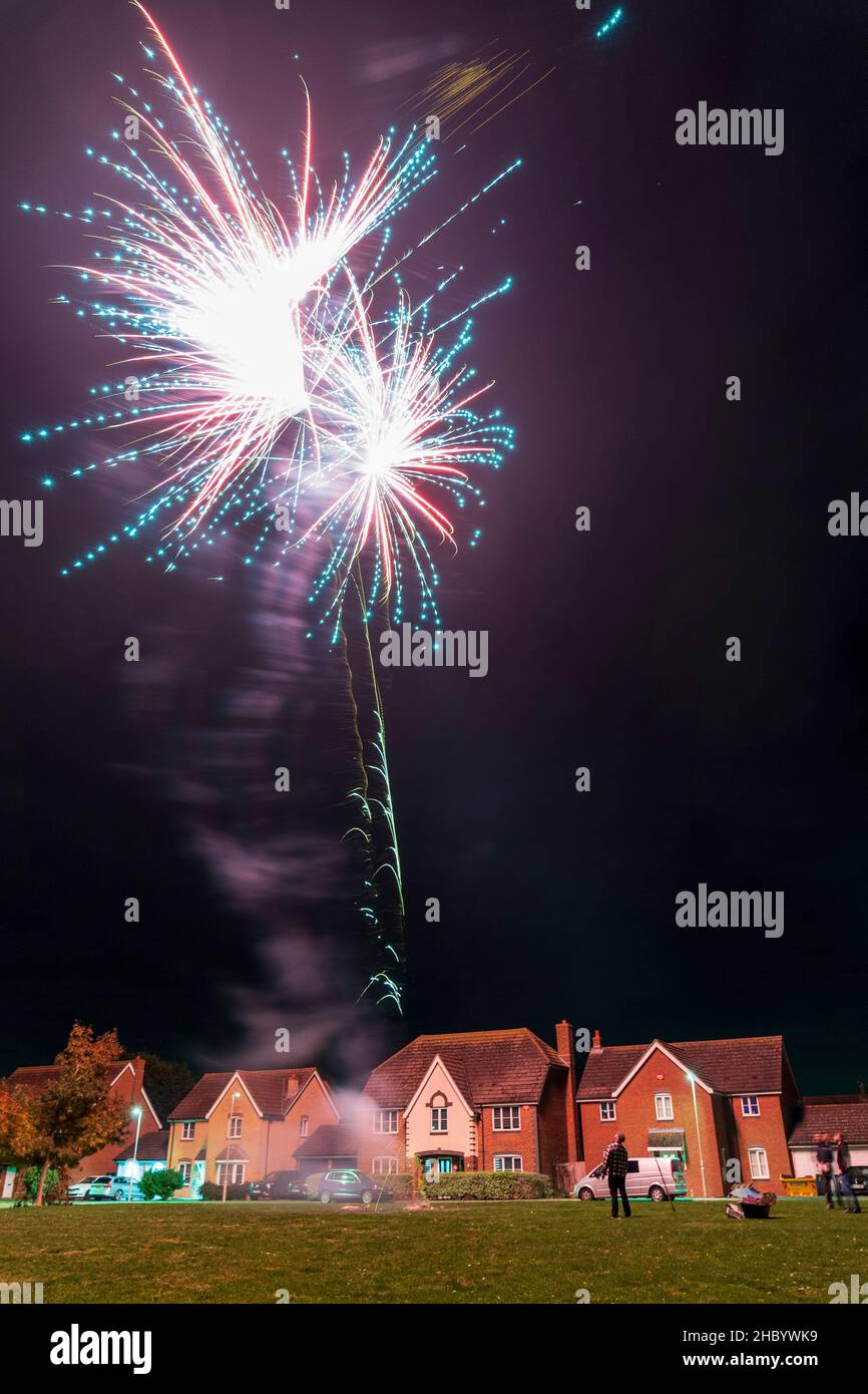 Firework display on village green with fireworks exploding on top of a