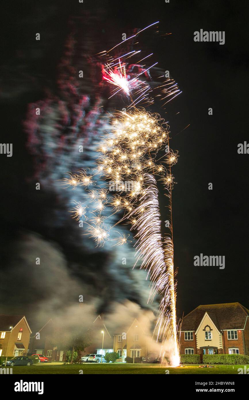 Firework display on village green with fireworks exploding on top of a