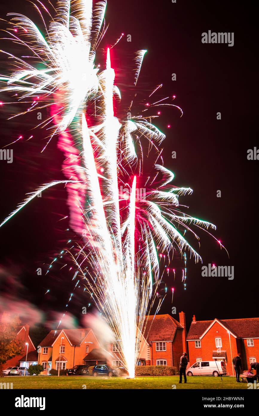 Firework display on village green with fireworks exploding on top of a