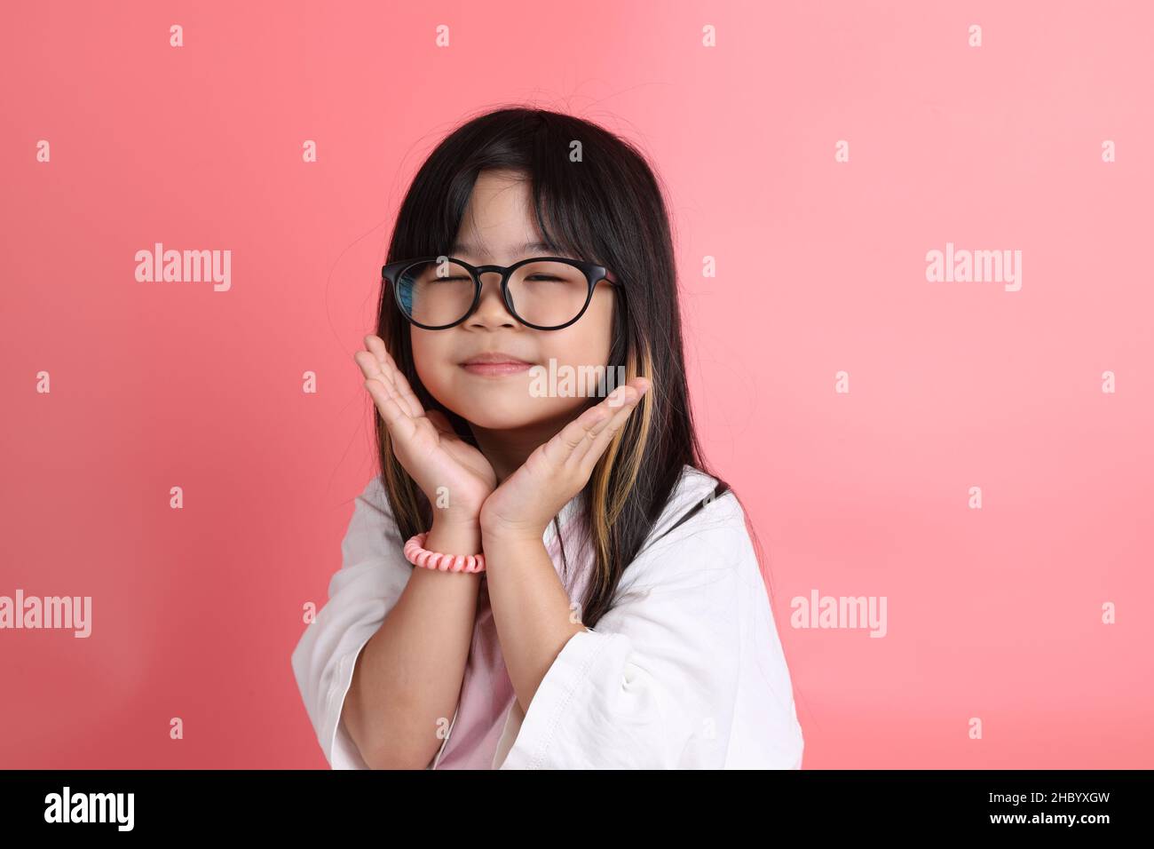 The young Asian girl portrait on the pink background. Stock Photo