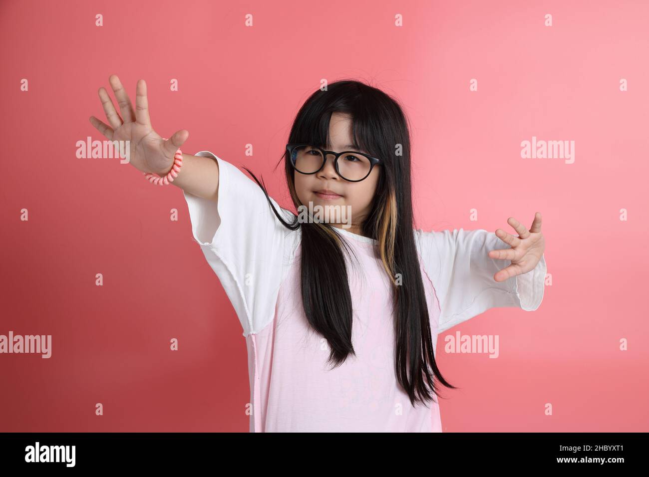 The young Asian girl portrait on the pink background. Stock Photo