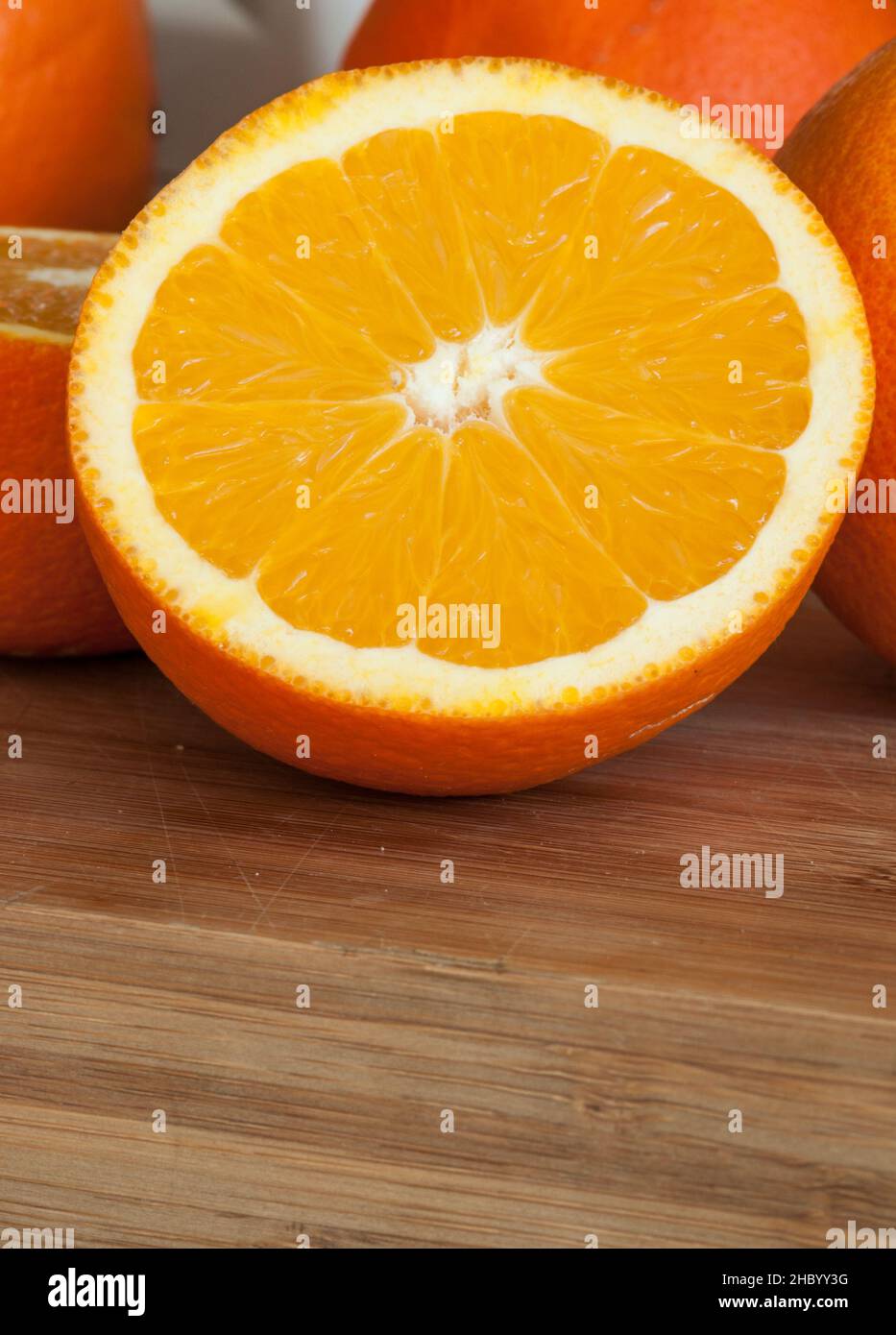 close-up of an orange cut in half on a wooden table Stock Photo