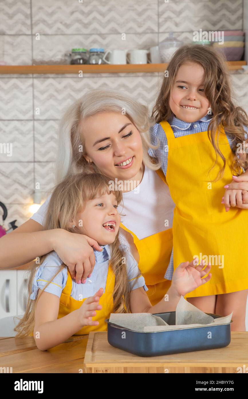 Caucasian Mom and two daughters taste the cookies just cooked together Stock Photo