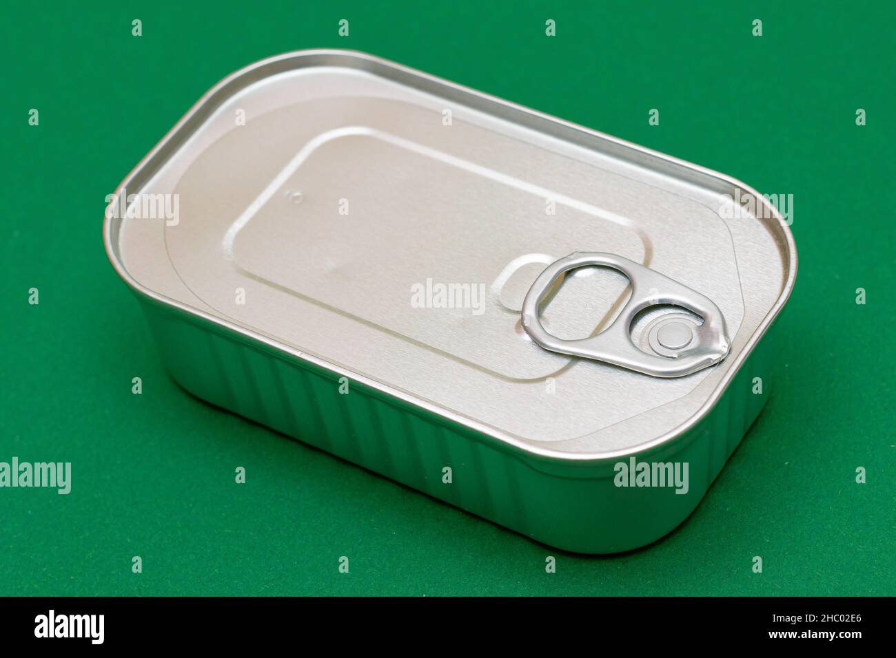 Unopened Tin Can with Blank Edge on Green Background. Canned Food