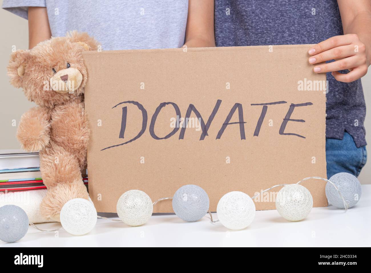 Volunteer hands holding brown piece of cardboard with inscription