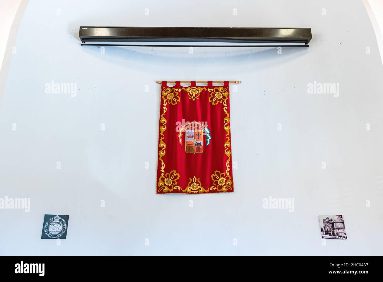 Huelva, Spain - December 18, 2021: Banner with the coat of arms of the town of Minas de Riotinto hanging on the wall of the old Anglican Church used b Stock Photo