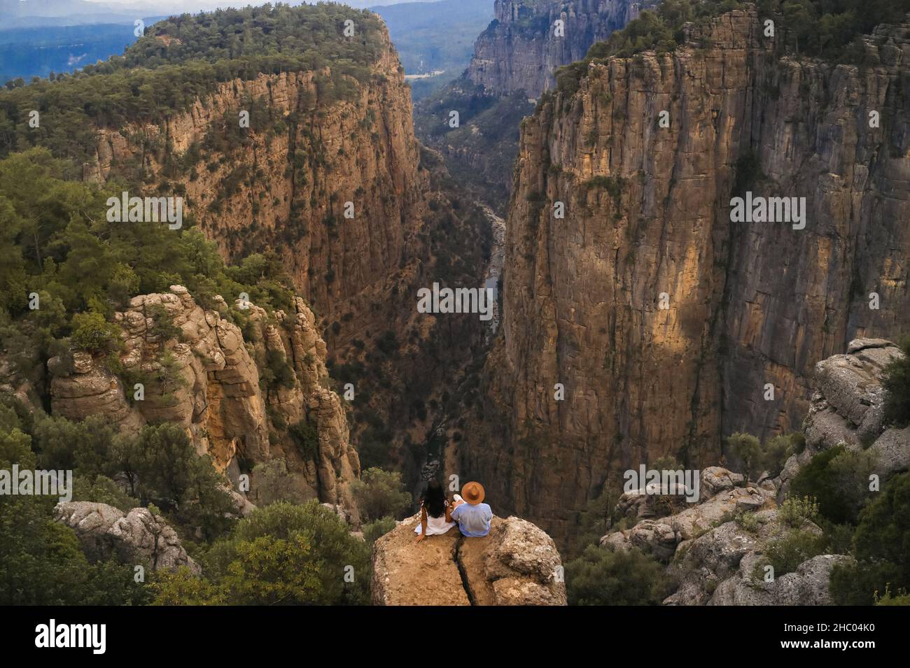 Tourist couple on the edge of a cliff of Tazi Canyon in Manavgat, Antalya, Turkey. Greyhound Canyon, Wisdom Valley. Stock Photo